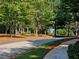 Scenic street view with trees lining the road and a charming pergola in the distance at 3447 Dogwood Pass, Lithonia, GA 30038