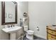 Traditional half bath featuring a pedestal sink, decorative mirror and blue tile flooring at 1227 Magnolia Path Way, Sugar Hill, GA 30518