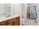 A bathroom with dark wood cabinets and a glass shower at 1227 Magnolia Path Way, Sugar Hill, GA 30518