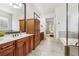 Bathroom featuring granite countertops, wooden cabinets, walk-in shower and access to the main bedroom at 1227 Magnolia Path Way, Sugar Hill, GA 30518