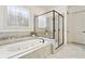 A tiled bathroom with a large soaking tub and glass shower showcasing stylish fixtures and design at 1227 Magnolia Path Way, Sugar Hill, GA 30518