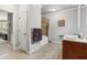 Well-lit bathroom featuring a white tub, tan tile, wood cabinet, and gray painted walls at 1227 Magnolia Path Way, Sugar Hill, GA 30518