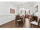Formal dining room featuring hardwood floors, wainscoting, and a view to the kitchen at 1227 Magnolia Path Way, Sugar Hill, GA 30518