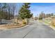 Gated community entrance with stone pillars and manicured landscaping at 1227 Magnolia Path Way, Sugar Hill, GA 30518