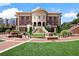 Elegant brick building featuring classic architecture, a landscaped lawn, and inviting entryway stairs at 1227 Magnolia Path Way, Sugar Hill, GA 30518