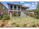 Back exterior view of the home featuring a large covered patio, porch, and expansive yard at 1227 Magnolia Path Way, Sugar Hill, GA 30518