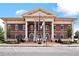 Front exterior of a stately building featuring classic architecture, American flags, and ample parking at 1227 Magnolia Path Way, Sugar Hill, GA 30518