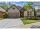 Charming brick and stone home with a two-car garage, manicured landscaping, and inviting curb appeal at 1227 Magnolia Path Way, Sugar Hill, GA 30518