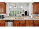 Close up on stainless appliances and granite countertop in the kitchen, with a view to the living room at 1227 Magnolia Path Way, Sugar Hill, GA 30518