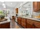 Well-appointed kitchen featuring wood cabinets, granite countertops, and a view into the adjacent living space at 1227 Magnolia Path Way, Sugar Hill, GA 30518