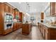 A spacious kitchen boasts wood cabinets, granite countertops, stainless steel appliances, and hardwood flooring at 1227 Magnolia Path Way, Sugar Hill, GA 30518