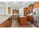 Open-concept kitchen with granite counters, stainless appliances, wood cabinets and a built-in desk area at 1227 Magnolia Path Way, Sugar Hill, GA 30518