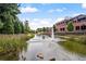 Picturesque pond featuring a fountain and walking path near brick buildings at 1227 Magnolia Path Way, Sugar Hill, GA 30518