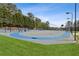 Community tennis court with well-maintained surface, lighting, and spectator benches at 1227 Magnolia Path Way, Sugar Hill, GA 30518