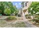 Lush backyard with mature trees, a grill, and a stone path leading to a well-maintained exterior with bright windows at 1315 Pembridge Nw Way, Kennesaw, GA 30152