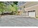 Attached two-car garage with a large driveway and view of the backyard and wooded area at 1315 Pembridge Nw Way, Kennesaw, GA 30152