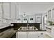 Kitchen featuring stainless steel sink, white cabinets, and stone countertops at 1315 Pembridge Nw Way, Kennesaw, GA 30152
