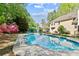 Refreshing backyard pool offers an idyllic scene with lush greenery, a patio, and direct home access at 1315 Pembridge Nw Way, Kennesaw, GA 30152