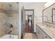 This bathroom offers granite counters, tile flooring, and a tub/shower combo at 4241 Woodward Walk Ln, Suwanee, GA 30024