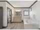 Bright bathroom featuring a large soaking tub with marble surround, a toilet room, and neutral paint and trim at 4241 Woodward Walk Ln, Suwanee, GA 30024