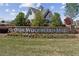 Community sign with colorful flowers, well-manicured lawn, and a welcoming entrance at 4241 Woodward Walk Ln, Suwanee, GA 30024