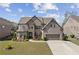 Beautiful brick home featuring manicured lawn, stone accents, and two-car garage at 4241 Woodward Walk Ln, Suwanee, GA 30024