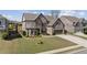 Well-kept brick home with lush lawn, tidy landscaping, and attached two-car garage at 4241 Woodward Walk Ln, Suwanee, GA 30024
