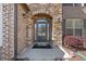 Inviting front entrance with stone archway, brick accents, and covered porch at 4241 Woodward Walk Ln, Suwanee, GA 30024