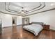 Spacious main bedroom featuring a tray ceiling with a ceiling fan and access to the ensuite bathroom and walk-in closet at 4241 Woodward Walk Ln, Suwanee, GA 30024