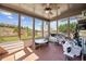Enclosed sunroom with large windows offers views of the backyard and includes a ceiling fan and outdoor furniture at 4241 Woodward Walk Ln, Suwanee, GA 30024