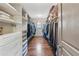 Generous walk-in closet features custom shelving and racks, and a well-lit interior space at 4241 Woodward Walk Ln, Suwanee, GA 30024