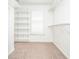Spacious walk-in closet with carpet, window and multiple built-in shelves at 6450 Oak Valley Dr, Cumming, GA 30040