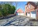 A long driveway leads to a brick home with a three-car garage and lush green landscaping at 6450 Oak Valley Dr, Cumming, GA 30040