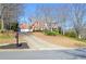 Charming two-story brick home with a long driveway and manicured lawn in a sunny neighborhood at 6450 Oak Valley Dr, Cumming, GA 30040