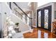 Welcoming foyer with decorative double doors, staircase, and hardwood floors, showcasing home's style at 6450 Oak Valley Dr, Cumming, GA 30040