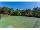 Full tennis court and basketball court surrounded by lush trees, offering a private and active lifestyle at 6450 Oak Valley Dr, Cumming, GA 30040