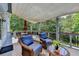 Relaxing back deck with comfortable wicker furniture and sunshade, surrounded by lush greenery for outdoor enjoyment at 8030 Eagle Lake Vw, Cumming, GA 30028