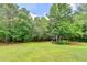 The spacious backyard offers a large grassy area surrounded by mature trees and a charming playhouse at 8030 Eagle Lake Vw, Cumming, GA 30028