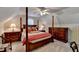 Spacious bedroom featuring a canopy bed, a ceiling fan, and two wooden nightstands with lamps on either side of the bed at 8030 Eagle Lake Vw, Cumming, GA 30028