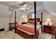 Well-lit bedroom with a canopy bed, featuring a ceiling fan, wooden nightstands with lamps, and a bench at 8030 Eagle Lake Vw, Cumming, GA 30028