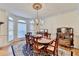 Elegant dining room featuring a chandelier, bay window and hardwood floors with an area rug at 8030 Eagle Lake Vw, Cumming, GA 30028