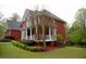 Back of two-story brick home featuring a back porch, manicured lawn, and privacy fence at 8030 Eagle Lake Vw, Cumming, GA 30028