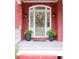 Charming red brick home exterior featuring a welcoming front door flanked by ferns in decorative pots at 8030 Eagle Lake Vw, Cumming, GA 30028