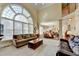 Open concept living room featuring large windows, fireplace, high ceilings and access to kitchen and upper level at 8030 Eagle Lake Vw, Cumming, GA 30028