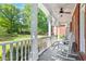 Inviting porch with white rocking chairs, ceiling fan, and a picturesque view of the lush, green yard at 8030 Eagle Lake Vw, Cumming, GA 30028