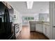 Modern kitchen with white cabinetry, stainless steel appliances, and a seamless connection to the dining area at 12495 Concord Hall Dr, Alpharetta, GA 30005