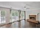 Light-filled living room with hardwood floors, a fireplace, and access to a deck overlooking the yard at 12495 Concord Hall Dr, Alpharetta, GA 30005