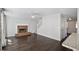 Bright living room with dark wood floors, white trim and a cozy brick fireplace at 12495 Concord Hall Dr, Alpharetta, GA 30005