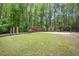 Community playground with swings, slides, and climbing structures nestled in a wooded area at 12495 Concord Hall Dr, Alpharetta, GA 30005