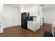 Bright kitchen with a black refrigerator, quartz countertops, and view to a stairway at 3848 Hester St, Duluth, GA 30097
